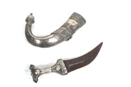 An Omani Jambiya dress dagger with white metal covered scabbard and grip (NB blade with surface