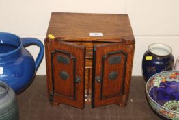 A late Victorian oak smokers cabinet in the form o