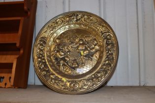 An embossed brass plaque fire screen