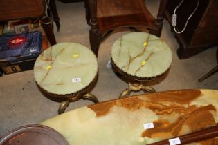 A pair of onyx and gilded brass tripod tables