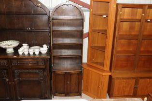 An oak Ercol style bookcase with arched top and cu