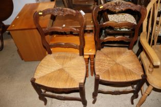 A pair of oak ladder back side chairs with rush se