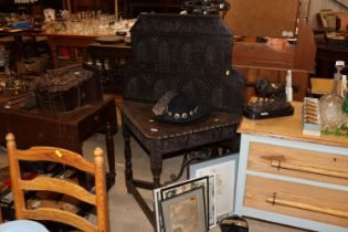 An antique oak corner table, the carved panel back