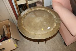 An Eastern brass occasional table on folding woode