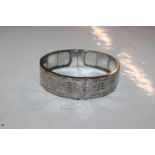 A white metal snap bangle, tested containing silve