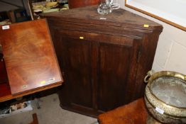 An antique oak hanging corner cupboard