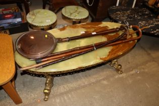 An onyx and gilded brass oval coffee table