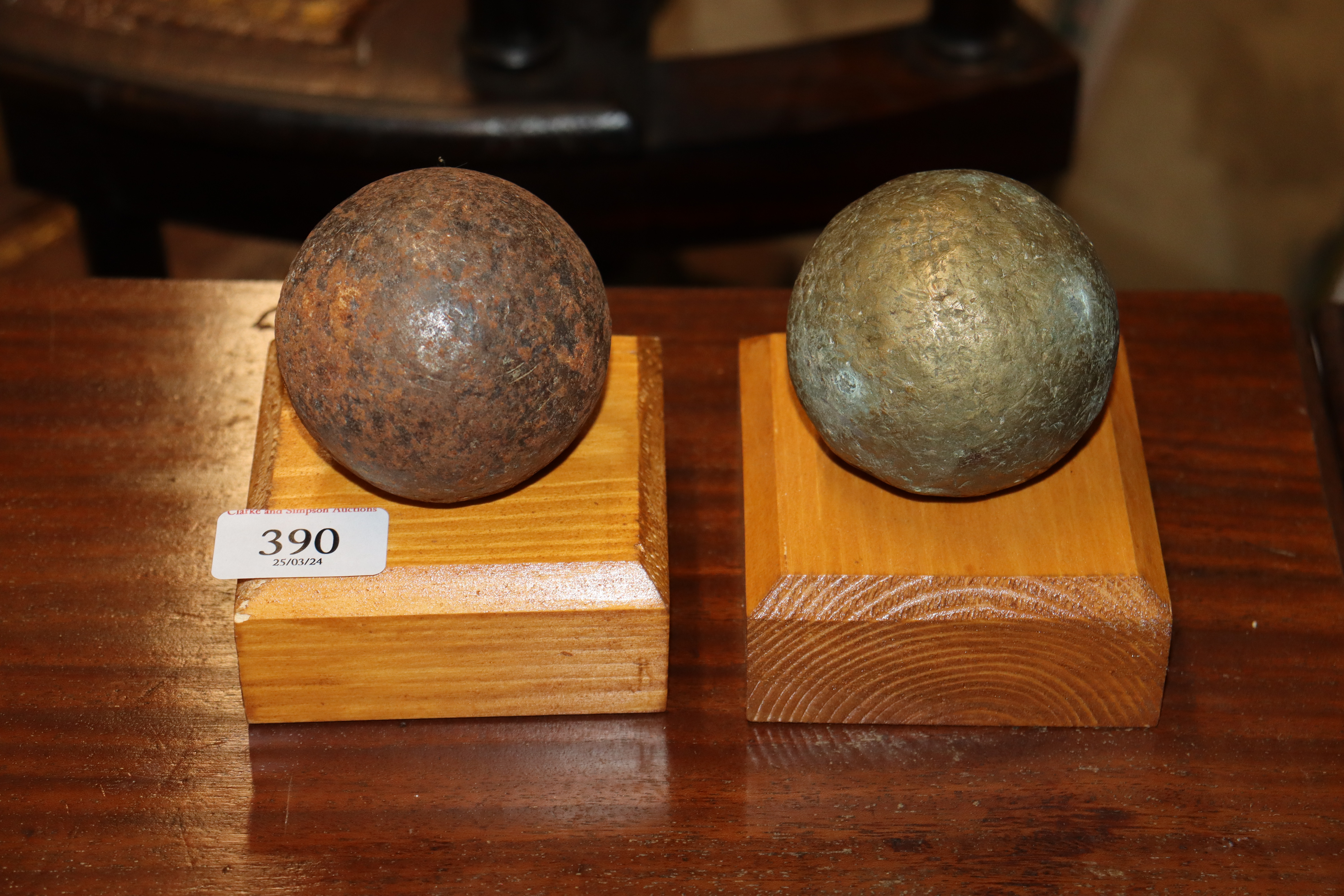 Two replica cannon balls on wooden bases