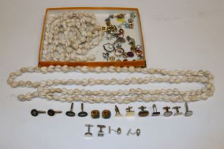 A box containing shell necklaces, various cuff-lin