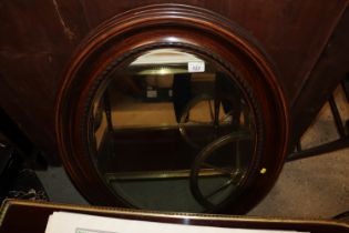 An oval simulated rosewood framed bevel edged wall