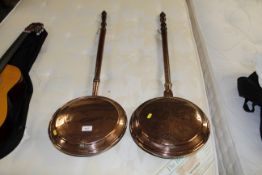 Two copper warming pans with turned wooden handles