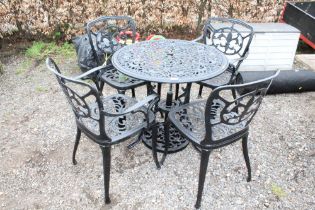 A metal garden table and a set of four matching ch