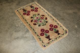 An approx. 4'5" x 2'3" floral patterned wool rug