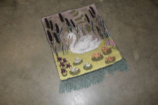 An approx. 2'8" x 2' wool rug depicting a swan