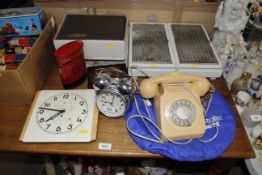 A rotary dial telephone, a wall clock, warming tra
