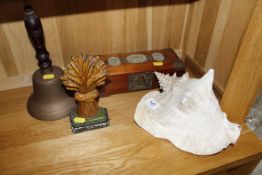 A conch shell; a door stop; a hand bell and an ori