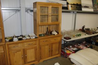 A modern light oak glazed cabinet fitted two drawe