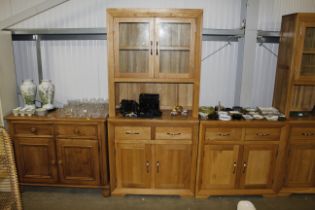 A modern light oak and glazed cabinet fitted two d