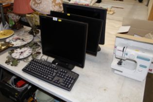 A Dell keyboard and three computer monitors lackin