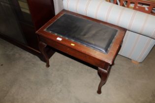 A mahogany piano stool raised on cabriole supports