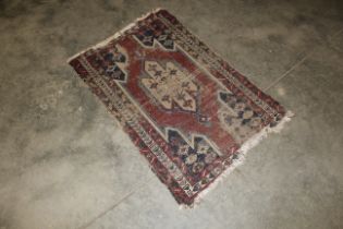 An approx. 3'10" x 2'6" red and blue patterned rug