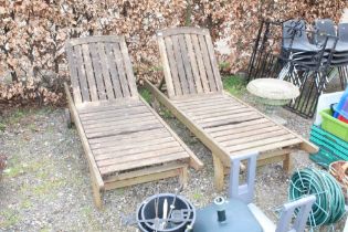 A pair of hardwood garden loungers