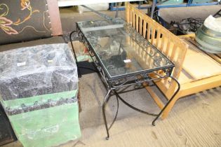 A wrought iron and glass topped table