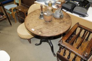 An antique tilt top table raised on tripod base