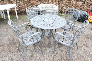 A metal garden table and a set of four matching chairs