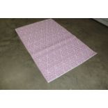 An approx. 6'3" x 4' pink and white modern pattern