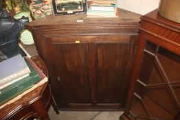 An antique oak hanging corner cupboard