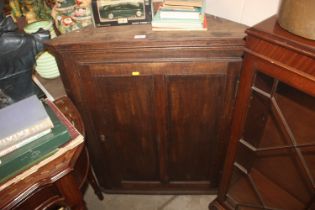 An antique oak hanging corner cupboard