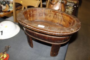 An antique Chinese wooden basin raised on four supports