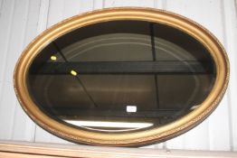 A gilt framed oval bevel edged wall mirror