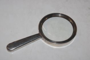 A silver magnifying glass, marks rubbed