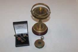 A brass compass on wooden stand; and a Neva gold p