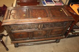 An antique oak panelled coffer on stand