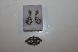 A silver and marcasite brooch with similar ear-rings set with amethyst coloured stones