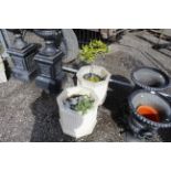 A pair of concrete garden planters both with conte