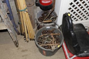 Two buckets containing various horse bits