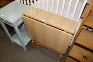 A wooden and laminate drop leaf kitchen table