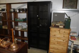 A tall black four shelved glass fronted IKEA displ