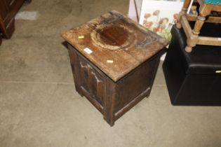 An oak coal box with linen fold panel decoration