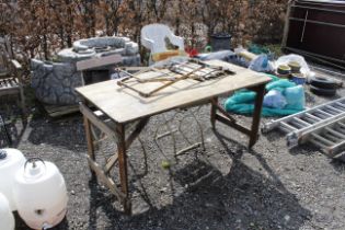 A trestle table and three folding pavilion chairs