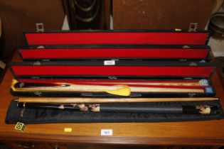 Four cased snooker / pool cues