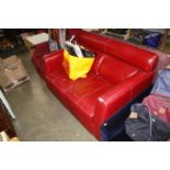 A red leather upholstered two seater settee