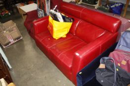 A red leather upholstered two seater settee