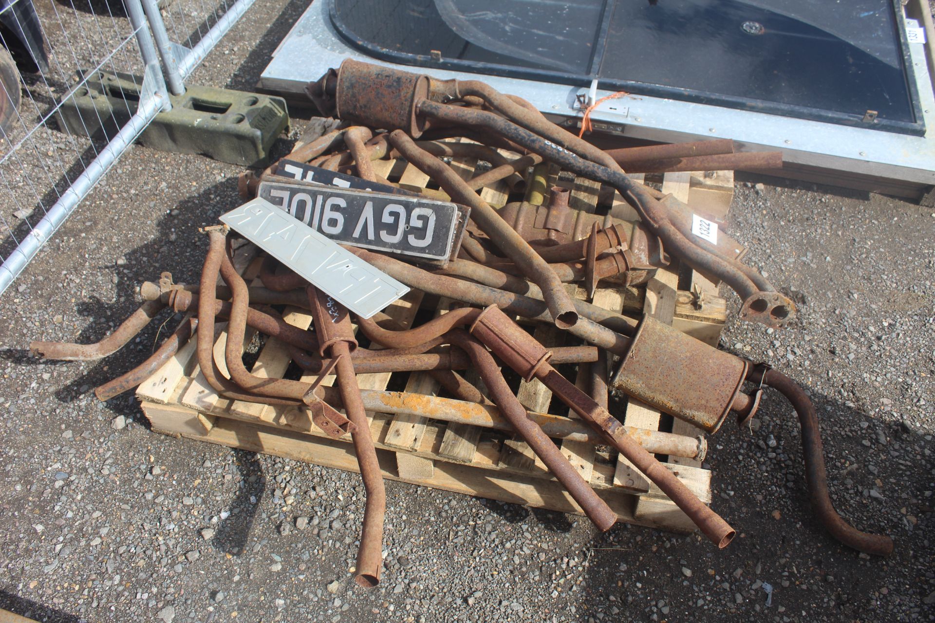 Various car exhausts and vintage number plates. V