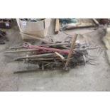 Large quantity of long handled tools.