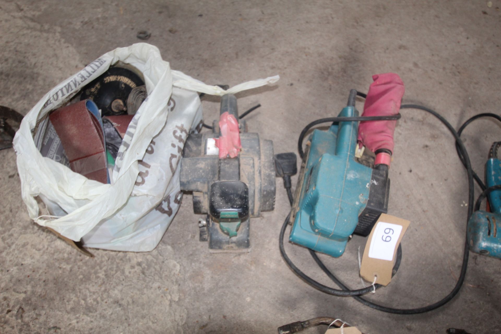 Makita belt sander, Skil planer and a bag containing various sanding belts etc.